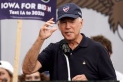 FILE - Democratic presidential candidate and former Vice President Joe Biden puts on a Beau Biden Foundation hat while speaking at the Polk County Democrats Steak Fry, in Des Moines, Iowa, Sept. 21, 2019.