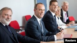 Britain's Secretary of State for Exiting the European Union Dominic Raab (C) and Britain's ambassador to the European Union Tim Barrow (L) attend a meeting with European Union's chief Brexit negotiator Michel Barnier in Brussels, Belgium, July 19, 2018.