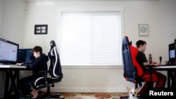 Foxton Harding, left and Adison Pucci, both 12, who attend Northshore Middle School, which has moved to online schooling for two weeks due to coronavirus concerns, work on school assignments at their home in Bothell, Washington, March 11, 2020.