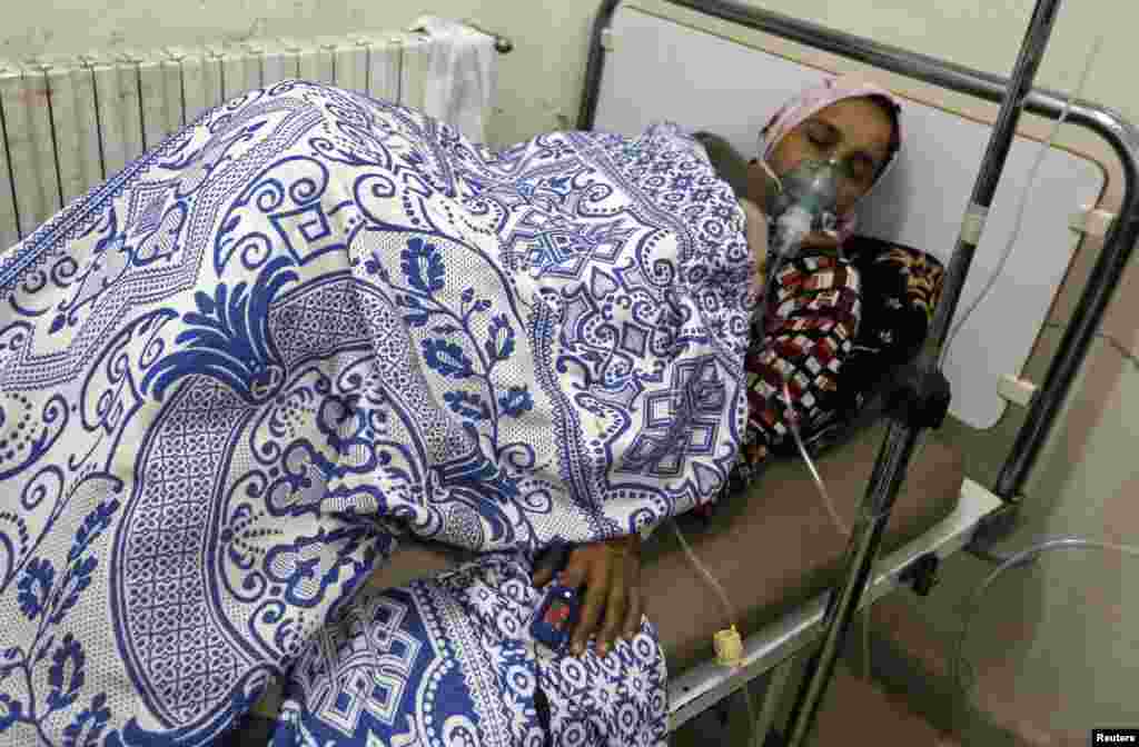 A woman affected by what activists say was a gas attack, receives treatment inside a makeshift hospital in Kfar Zeita village, in the central province of Hama, May 22, 2014.