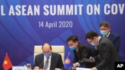 Vietnamese Prime Minister Nguyen Xuan Phuc, left, and his staff prepare documents ahead of the Special ASEAN summit on COVID-19 in Hanoi, Vietnam Tuesday, April 14, 2020. 