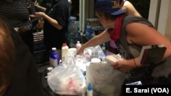 Volunteers hand out donated water bottles and antidotes to tear gas (masks, milk of magnesia, and vinegar) as protestors prepare to leave Romare Bearden Park and march through Charlotte, North Carolina, Sept. 24, 2016.
