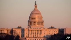 The light from the setting sun is reflected in the windows of the U.S. Capitol, Feb. 4, 2019, in Washington.