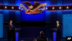 President Donald Trump, left, and Democratic presidential candidate former Vice President Joe Biden, listen to moderator Chris Wallace of Fox News during the first presidential debate Tuesday, Sept. 29, 2020, at Case Western University and Cleveland…