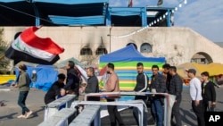 Protesters go through security inspection as they arrive to Tahrir Square, during ongoing protests, in Baghdad, Iraq, Dec. 25, 2019. 