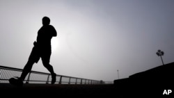 FILE - A man jogs at Pier A Park in Hoboken, New Jersey, Jan. 15, 2014. Atherosclerosis, or calcium deposits, in the cardiac arteries of young people have been found to dramatically shorten life expectancy, a new study found.