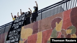 Protestors unfurl banner during a protest against police brutality near 2020 Democratic Convention in Milwaukee, Wisconsin, Aug. 18, 2020.