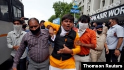 A demonstrator reacts as he is detained by plainclothes policemen during a protest demanding to boycott China-made products in Ahmedabad, India, July 6, 2020. 