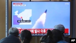 Decenas de personas observan el lanzamiento de los supuestos misiles norcoreanos en un programa de noticias en Corea del Sur.