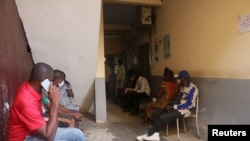 FILE - Patients wait their turn at Saint Paul Catholic Hospital, to receive free concoctions made by Samuel Kleda, Archbishop of Douala, who claims that they have helped treat COVID-19 patients, in Douala, Cameroon, June 9, 2020.