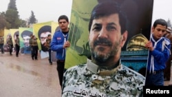 Lebanon's Hezbollah boy scouts carry a picture of Hezbollah commander Hassan al-Laqis during his funeral in Baalbeck, in Lebanon's Bekaa valley, Dec. 4, 2013. 