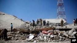 FILE - Policemen gather at the site of a Saudi-led airstrike on the police headquarters in Sana'a, Yemen, Jan. 18, 2016.