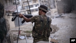 A Free Syrian Army fighter fires his weapon at Syrian Army positions in Aleppo, Syria, September 11, 2012. 