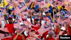 Young Malaysians wave flags during rehearsals for National Day celebrations, marking the anniversary of the country's independence, at the Independence Square in Kuala Lumpur, in this August 29, 2012 file photo. 