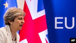FILE - British Prime Minister Theresa May prepares to address a media conference at an EU summit in Brussels, June 23, 2017. 