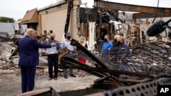 President Donald Trump talks to business owners, Sept. 1, 2020, as he tours an area damaged during demonstrations after a police officer shot Jacob Blake in Kenosha, Wis.