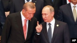FILE - Russian President Vladimir Putin, right, and Turkish President Recep Tayyip Erdogan chat during a group photo session for the G-20 Summit at the Hangzhou International Expo Center in Hangzhou in eastern China's Zhejiang province, Sept. 4, 2016.