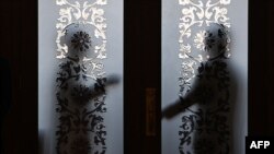 Security guards stand behind a glass door outside the Tibet hall in the Great Hall of the People during the National People's Congress in Beijing on March 6, 2024. Policymakers meeting in Beijing this week said China needs to increase employment and stabilize its property market.