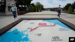 Visitors walk by a map of two Koreas showing North Korea's capital Pyongyang and South Korea's capital Seoul at the Imjingak Pavilion in Paju, near the border with North Korea, South Korea, Sept. 24, 2021.