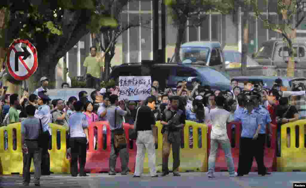 A woman protests outside the Jinan Intermediate People&#39;s Court in Jinan, eastern China&#39;s Shandong province, August 21, 2013. 