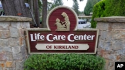 A sign at the entrance of the Life Care Center is shown in Kirkland, Wash., near Seattle, Tuesday, March 3, 2020. Dozens of people associated with the facility are reportedly ill with respiratory symptoms or hospitalized and are being tested for the…