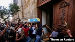 Demonstators smash down a door of the Jalisco State Government Palace in Guadalajara, Mexico, on June 4, 2020, during a protest to demand justice for Giovanni Lopez, who died after being arrested for not wearing a face mask in public.
