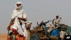 FILE - Gen. Mohammed Hamdan Dagalo, the deputy head of the military council sits on his vehicle surrounded by soldiers from the Rapid Support Forces, RSF, unit during a military-backed tribal rally, in the East Nile province, Sudan, June 22, 2019.