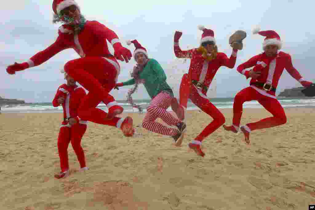 British travelers, left to right, Liam Skalley, John Arthurs, Ben Saunders, Sam Hope and Liam Fillingham kick up their heels as they celebrate Christmas Day at Bondi Beach in Sydney, Australia, December 25, 2012.