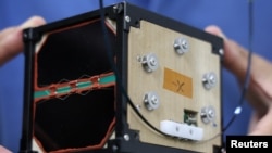 Takao Doi, a former Japanese astronaut and professor at Kyoto University, holds an engineering model of LignoSat during an interview with Reuters at his laboratory at Kyoto University in Kyoto, Japan, October 25, 2024. (REUTERS/Irene Wang)