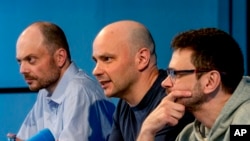 Звільнені російські в'язні Ілля Яшин (п), Андрій Пивоваров і Володимир Кара-Мурза на пресконференції в Бонні, Німеччина, у п'ятницю, 2 серпня 2024 року, через день після того, як їх звільнили в рамках обміну між Росією і США. (Фото AP/Майкл Пробст)