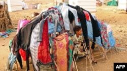 FILE - A displaced child who fled the fighting sits at a makeshift camp in the district of Abs, in Yemen's northwestern Hajjah province, June 10, 2019.