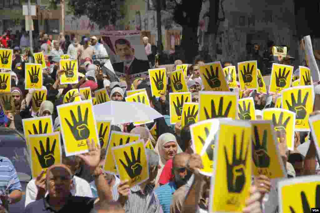 Demonstrators hold up four fingers, a symbol of their solidarity with the the destroyed sit-in protest known as Rabaa, which means four or fourth in Arabic, Cairo, August 23, 2013. (H. Elrasam for VOA)
