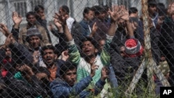 FILE - Migrants protest the EU-Turkey deal about migration inside the entrance of Moria camp in the Greek island of Lesbos, April 5, 2016. 