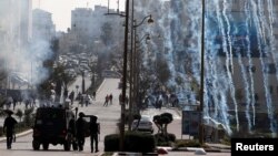 Israeli forces fire tear gas canisters at Palestinian protesters during clashes near the Jewish settlement of Beit El, in the Israeli-occupied West Bank March 20, 2019. 