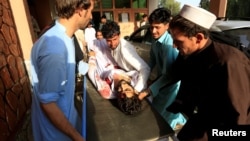 Relatives carry an injured man into a hospital after a car bomb was set off in Jalalabad, Afghanistan, June 16, 2018.