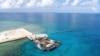 In this photo provided by the Department of National Defense, ships carrying construction materials are docked at the new beach ramp at the Philippine-claimed island of Pag-asa in the South China Sea on June 9, 2020.