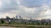 FILE - A section of Nairobi's city scape is seen May 16, 2019, through a crisscross of electrical lines as a man on his morning commute walks along Mbagathi Way in the Kenyan capital's southern sector.