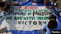 কলম্বিয়া বিশ্ববিদ্যালয়ের শিক্ষার্থীরা ব্যানার লিখছে। রাফার ফিলিস্তিনিদের লেখা একটি বার্তার প্রত্যুত্তর লিখেছে তারা। ফটোঃ ২৮ এপ্রিল, ২০২৪।