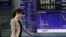 A woman walks by a securities' firm in Tokyo, Friday, Sept. 24, 2010. The Nikkei 225 stock average lost 1.3 percent to 9,446.71 in morning trading as Asian stock markets mostly fell Friday after a jump in U.S. unemployment claims provided more evidence of