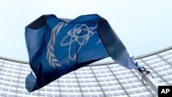 Bendera Badan Tenaga Atom Internasional (IAEA) berkibar di depan markas besar (IAEA) di Vienna International Center, Wina, Austria, 27 Maret 2009. (Foto:dok)