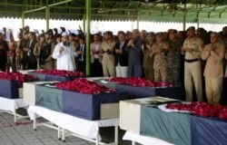 FILE - People pray at the funeral for victims of a bombing near a police checkpoint, in Lahore, Pakistan, March 15, 2018. The country's main Taliban group Tehrik-e-Taliban Pakistan claimed responsibility for the bombing.