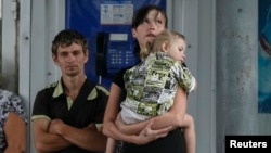 Local residents wait for a bus as they try flee fighting in the eastern Ukrainian city of Slovyansk June 10, 2014.