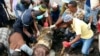 Locals and rescuers retrieve a mattress from a site where two houses were crushed by the collapse of a massive, sprawling dumpsite when rains poured in Pemba city on the northeastern coast of Mozambique, Monday, April, 29, 2019.