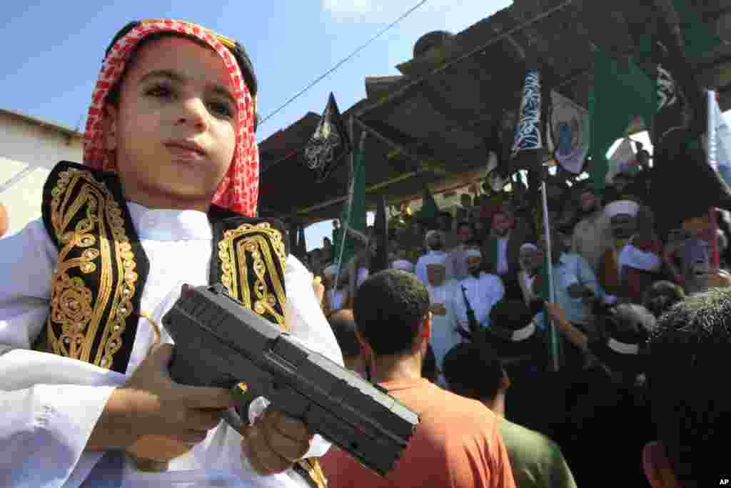 A boy holds a toy gun during a protest in the Palestinian refugee camp of Ain el-Hilweh near Sidon, Lebanon, September 14, 2012.