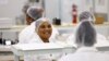 FILE - Women interact at their solar panel factory called Ener-G-Africa, where they produce high-quality solar panels made by an all-female team, in Cape Town, South Africa, Feb. 9, 2023.