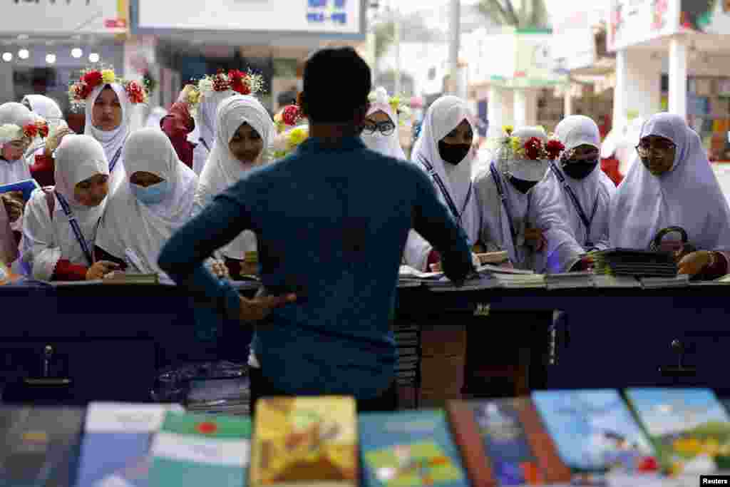 Siswa memeriksa buku-buku yang dipajang di sebuah stan dalam Pameran Buku Amar Ekushe selama sebulan, di Pameran Buku Tahunan, di Suhrawardi Udyan, di Dhaka, Bangladesh, Selasa, 18 Februari 2025. (Foto: Mohammad Ponir Hossain/Reuters)