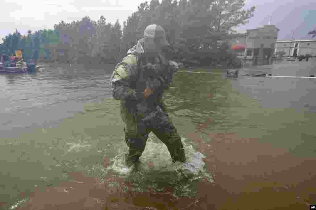 2017年8月27日，德克萨斯州休斯敦的热带风暴哈维带来洪水。救援人员把一家人撤离后，又救出他们的两只狗。