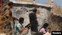 Free Syrian Army fighters carry their weapons as they take positions near Hanano Barracks, which is controlled by forces loyal to Syria's President Bashar al-Assad, in Aleppo, Sept. 11, 2013.