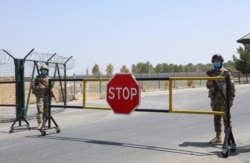 FILE - Border guards are seen at a checkpoint at the Uzbekistan-Afghanistan border in Ayritom, Uzbekistan, Aug. 15, 2021.