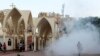 Coptic Christians run inside the main cathedral in Cairo as police fire tear gas during clashes with Muslims standing outside the cathedral April 7, 2013.